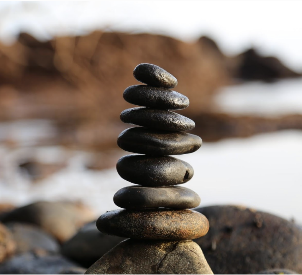 Image of a cairn or stacked stones on the Washington coastline. This photo is meant to represent balance in the aim to overcome negative thoughts.