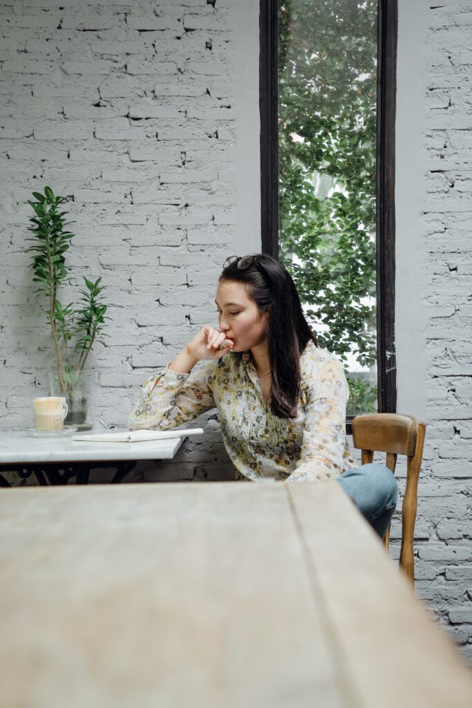 Solutions-based therapy client in Florida sitting at a table in thought