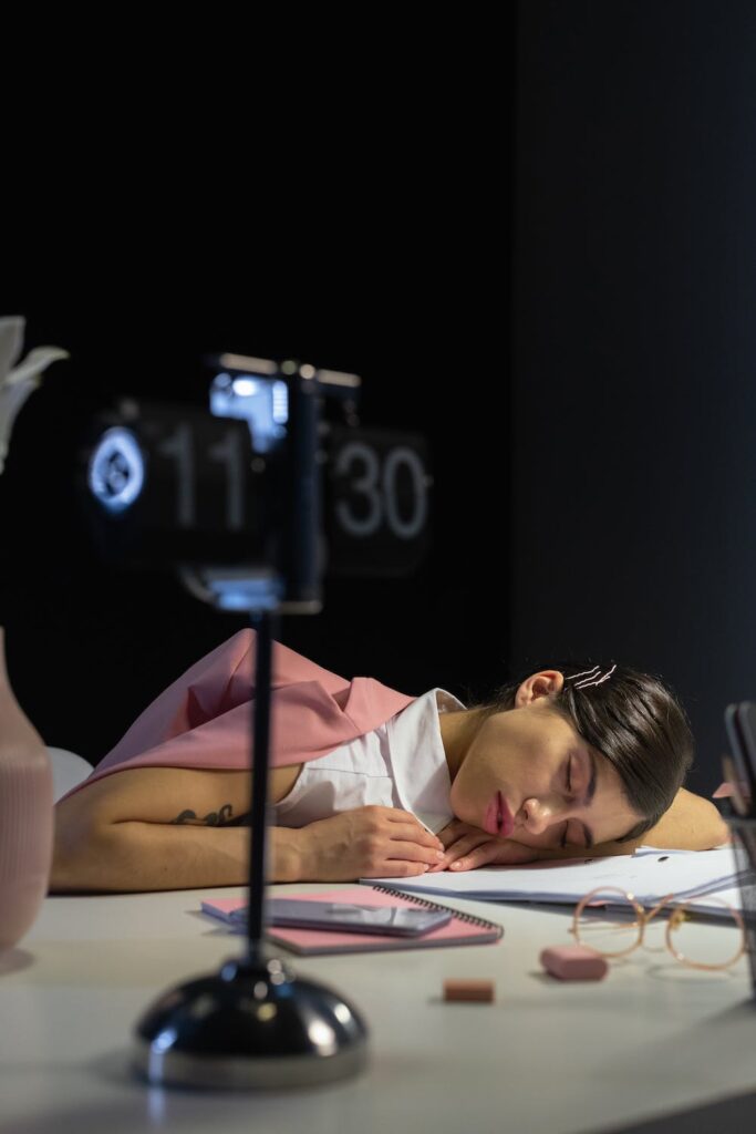 woman falling asleep at work desk while trying to keep up with impossible demands because of imposter syndrome